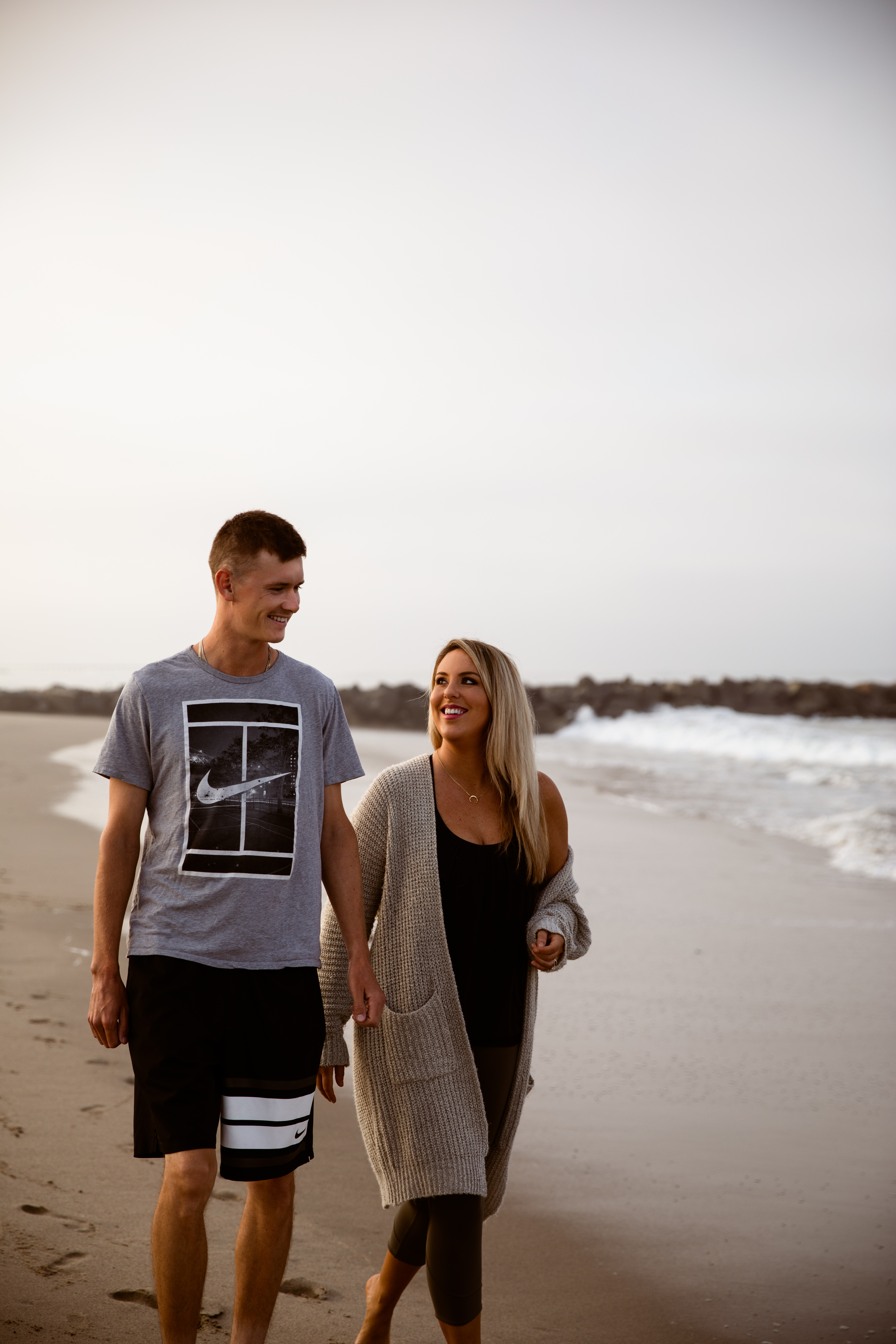 Newport Beach couple walking beach sunrise